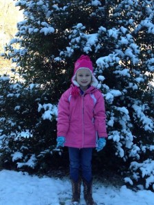 Rachel in front of a snowy holly tree at Mom and Dad's house